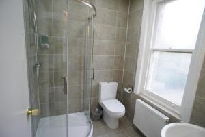 a bathroom with a toilet and a glass shower at Applewood Hotel in Bournemouth