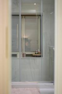 a bathroom with a shower with a glass door at Naias Aegina, Sea-front apartment 95 sqm in Aegina Town