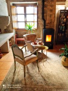 sala de estar con mesa, sillas y chimenea en Hostal Pension Artilleiro, en Santiago de Compostela