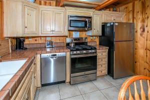 a kitchen with stainless steel appliances and wooden cabinets at Switzerland Ski Chalet-845 by Big Bear Vacations in Big Bear Lake
