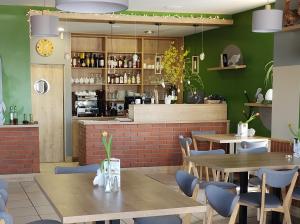 a restaurant with tables and chairs and a counter at Hotel Przylesie in Sierosław