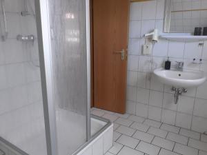 ein Badezimmer mit Dusche und Waschbecken in der Unterkunft Weinhaus Hotel in Norddeich