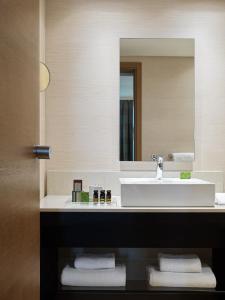 a bathroom with a white sink and a mirror at Galaxy Iraklio Hotel in Heraklio