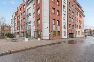 an empty street in front of a brick building at Downtown Apartments City Center Tartaczna in Gdańsk