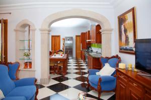 cocina con arco y sillas azules en una habitación en YourHouse Can Peret, modern town house in Sa Pobla with private pool, en Sa Pobla