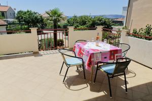 een tafel en stoelen op een balkon met een roze tafel en stoelen bij Apartments Nataša in Krk