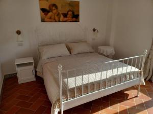 Un dormitorio con una cama blanca y una pintura en la pared en AGRITURISMO ANTICHI SAPORi, en Polvica