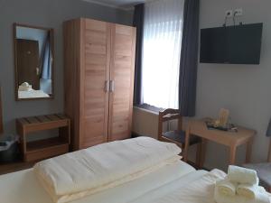 Weinhaus Hotel في نورديش: غرفة نوم بسرير وكابينة ومرآة