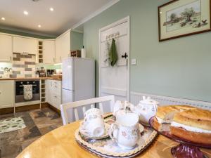 a kitchen with a table with tea sets on it at Coed Y Glyn in Bala