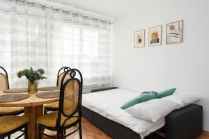 a bedroom with a bed and a table and chairs at Sleepway Apartments -Boho Chic in Poznań