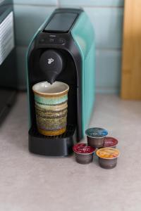 a coffee maker is pouring coffee into a cup at Sleepway Apartments -Boho Chic in Poznań