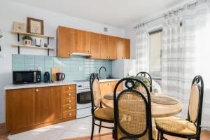 a kitchen with a table and chairs in a room at Sleepway Apartments -Boho Chic in Poznań