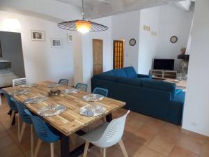 a living room with a wooden table and a blue couch at Villa Sampa in Le Beausset