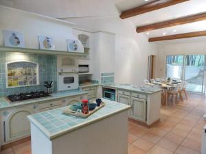 a large kitchen with a stove and a table at Villa Sampa in Le Beausset