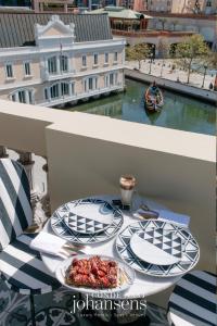 a table with two plates of food on a balcony at 1877 Estrela Palace in Aveiro