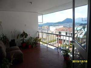 a living room with a balcony with plants at Casa Blanca Hostal Manizales in Manizales