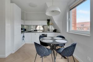 a kitchen with a table and chairs and a window at Downtown Apartments City Center Tartaczna Apartments & Parking in Gdańsk