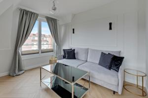 a living room with a couch and a large window at Downtown Apartments City Center Tartaczna Apartments & Parking in Gdańsk