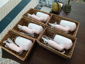 four wicker baskets filled with white and gray dishes at Nine Smiths Hotels Chiangmai in Chiang Mai