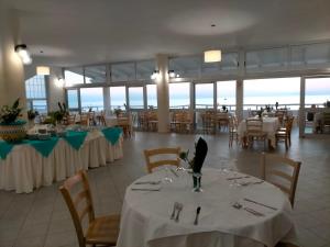 a dining room with tables with white table cloth at Villaggio Hotel Agrumeto in Capo Vaticano