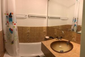 a bathroom with a sink and a toilet and a tub at studio 4 personnes rez de jardin a Ancelle 05260 in Château-dʼAncelle