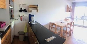 a kitchen with a table and a dining room at studio 4 personnes rez de jardin a Ancelle 05260 in Château-dʼAncelle