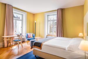A bed or beds in a room at Alma Hotel