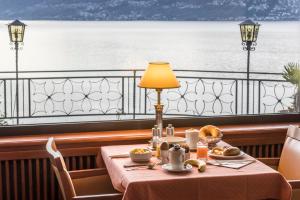 ein Tisch mit Speisen darauf und Blick aufs Wasser in der Unterkunft Boutique Hotel La Rocca in Ronco sopra Ascona