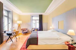 A bed or beds in a room at Alma Hotel