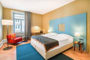 A bed or beds in a room at Alma Hotel