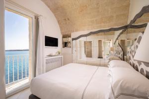 a bedroom with a large bed and a large window at Hotel Don Ferrante in Monopoli +37 photos