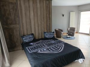 a bedroom with a bed with a black blanket and chairs at La pacheca in Lazise