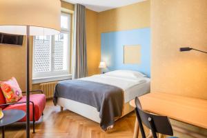 A bed or beds in a room at Alma Hotel