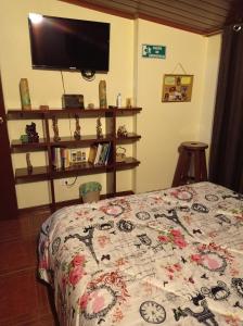 1 dormitorio con 1 cama con edredón y TV en Habitación 5 minutos aeropuerto, en Bogotá