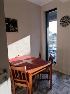 a dining room table with two chairs and a window at Rimimi Apartamente in Mamaia Nord +15 photos