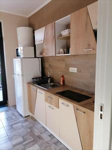 a kitchen with a sink and a white refrigerator at Rimimi Apartamente in Mamaia Nord
