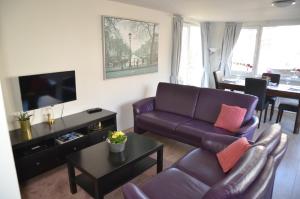 salon z kanapą i telewizorem w obiekcie Woonboot Irene w Alkmaarze