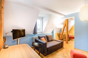 a living room with a couch and a tv at Alma Hotel in Zürich