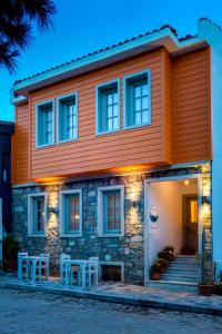 a orange house with two stools in front of it at Meraki Bozcaada in Bozcaada