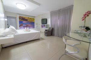 a bedroom with a bed and a glass table at Marruá Hotel in Bonito