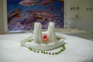 a towel angel on a bed with a rose at Marruá Hotel in Bonito
