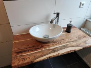 a bathroom with a white bowl sink on a wooden counter at ZEN Apartments - Exklusive Suite - Luxus - Boxspringbett in Karlsruhe