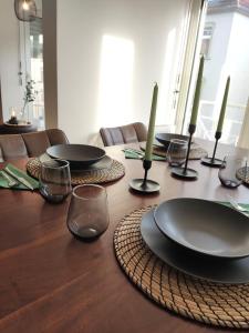 a wooden table with black plates and candles on it at ZEN Apartments - Exklusive Suite - Luxus - Boxspringbett in Karlsruhe