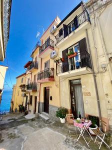 a building with a table and chairs in front of it at La Casetta In Centro - Holiday House in Scilla