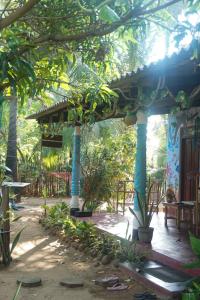 a pavilion with blue columns in a garden at Akki's Hostel in Trincomalee