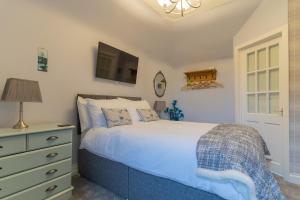 a bedroom with a bed and a tv on the wall at Galvelbeg House self catering apartment in Crieff