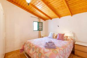 ein Schlafzimmer mit einem Bett und einer Holzdecke in der Unterkunft La Cueva de Tito-Casa Cueva en plena naturaleza in Santa Brígida