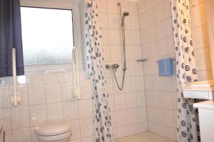 a bathroom with a shower with a toilet and a sink at Haus Witten Höhen Ferienwohnungen in Cuxhaven