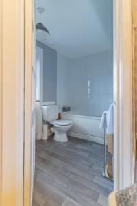 a bathroom with a toilet and a bath tub at Galvelbeg House self catering apartment in Crieff