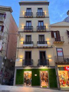 a tall white building with balconies on a street at Studio Apartments Centro Storico Via Manno in Cagliari